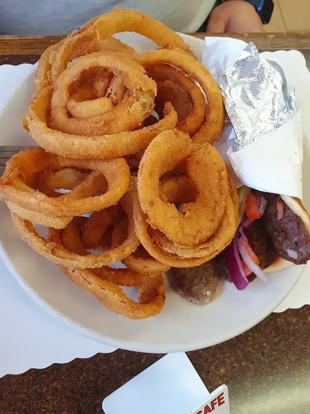 A pile of onion rings over a wrapped gyro at Harry's Cafe, Katella Ave, Stanton, CA