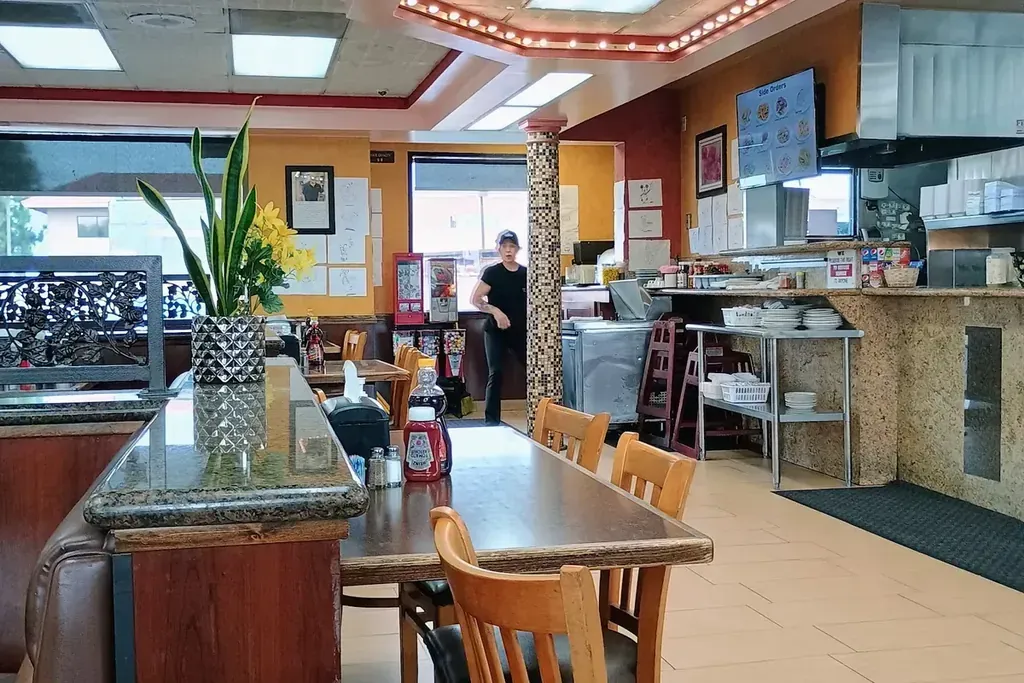 The dining room with wood chairs and booths at Harry's Cafe, Katella Ave, Stanton, CA