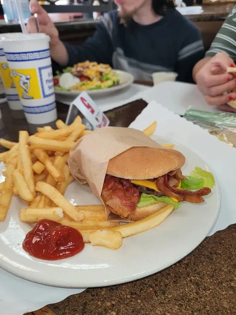 A cheeseburger with a ring of onion rings on a plate at Harry’s Cafe, Katella Ave, Stanton, CA.