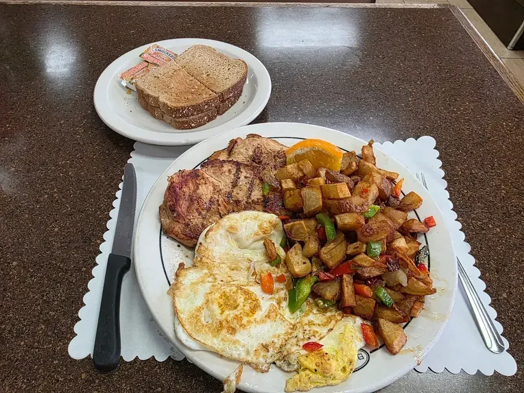 Grilled pork chops with fried eggs, home fries, and toast from the breakfast specials menu at Harry’s Cafe, Katella Ave, Stanton, CA.