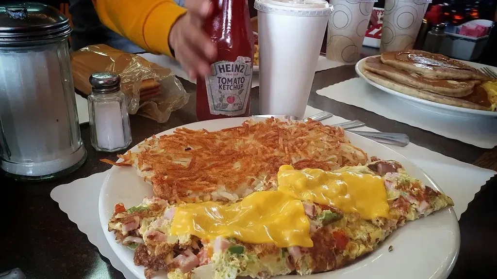 A ham and vegetable omelette under melted cheese beside crisp hash browns from the omelette menu at Harry’s Cafe, Katella Ave, Stanton, CA.