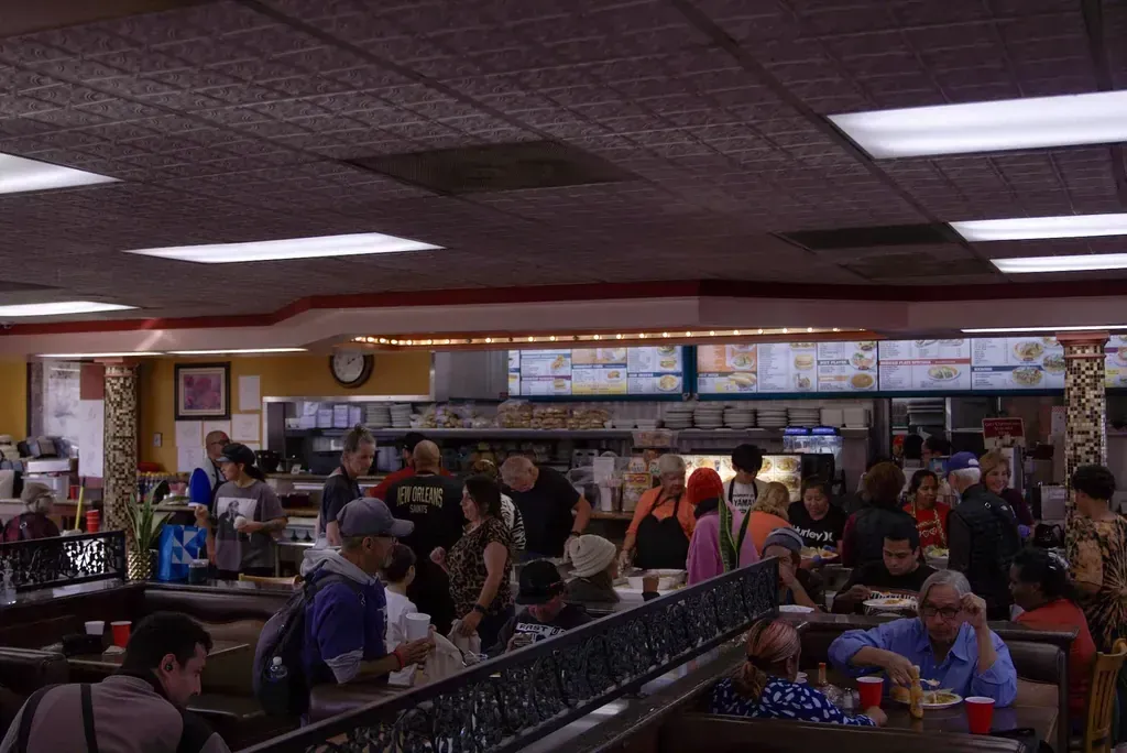 A full dining room of guests at the booths and tables of Harry's Cafe, a diner on Katella Ave, Stanton, CA
