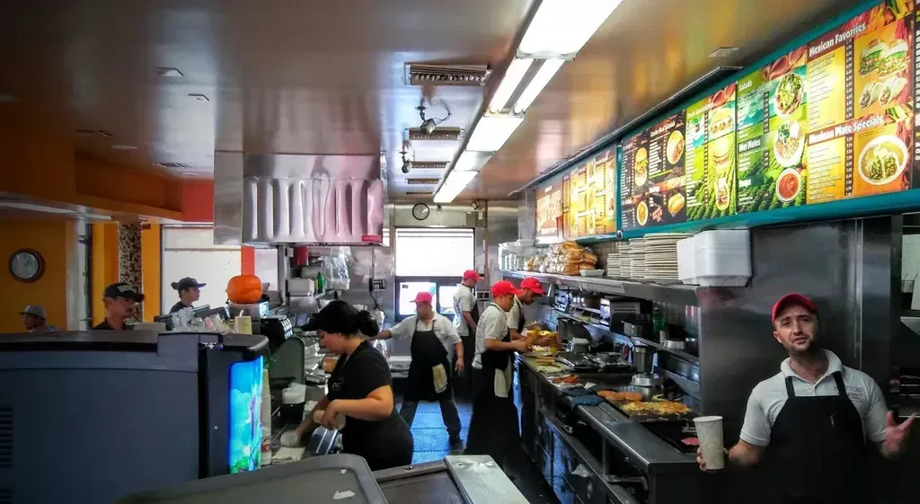 The kitchen team cooking on the line at the Harry's Cafe restaurant on Katella Ave, Stanton, CA