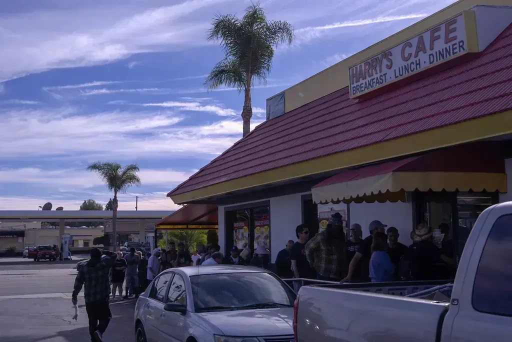 The Harry’s Cafe storefront and drive-thru sign on Katella Avenue in Stanton, CA, seen from across the street.