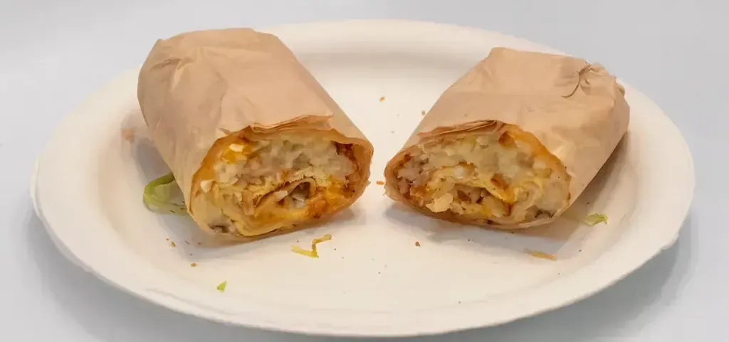 Harry’s Burrito covered in red sauce and melted cheese on a plate at Harry’s Cafe, Katella Ave, Stanton, CA.