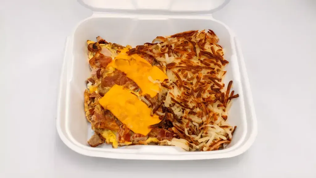 A plate of hash browns and a side of toast next to a cheese omelette at Harry's Cafe, a breakfast restaurant on Katella Ave, Stanton, CA.