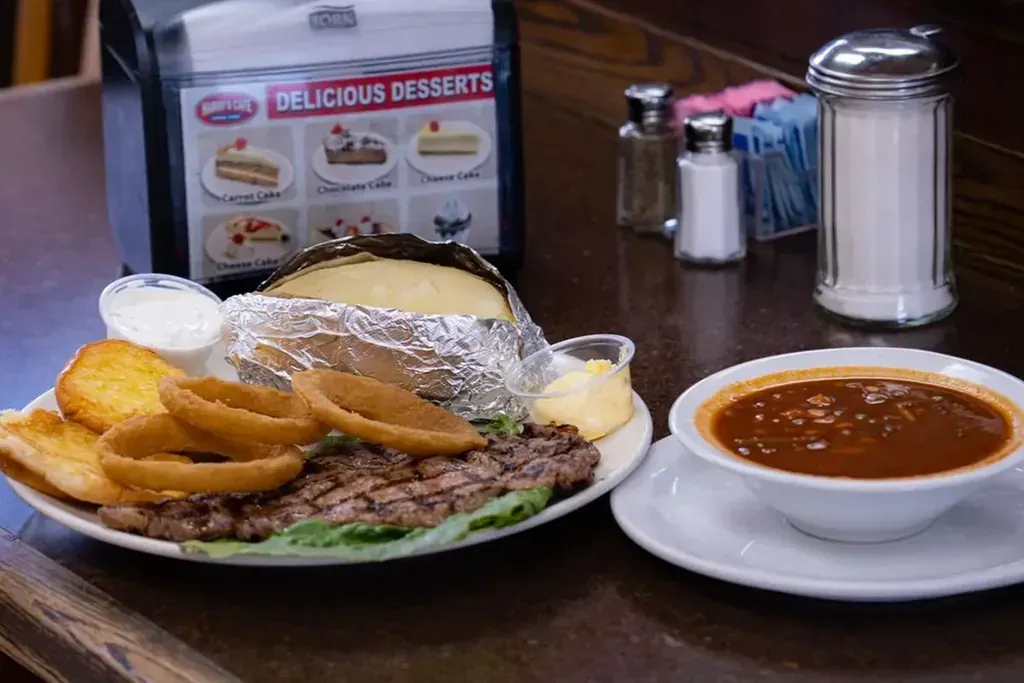 A bowl of chili next to a steak dinner at Harry's Cafe, Katella Ave, Stanton, CA